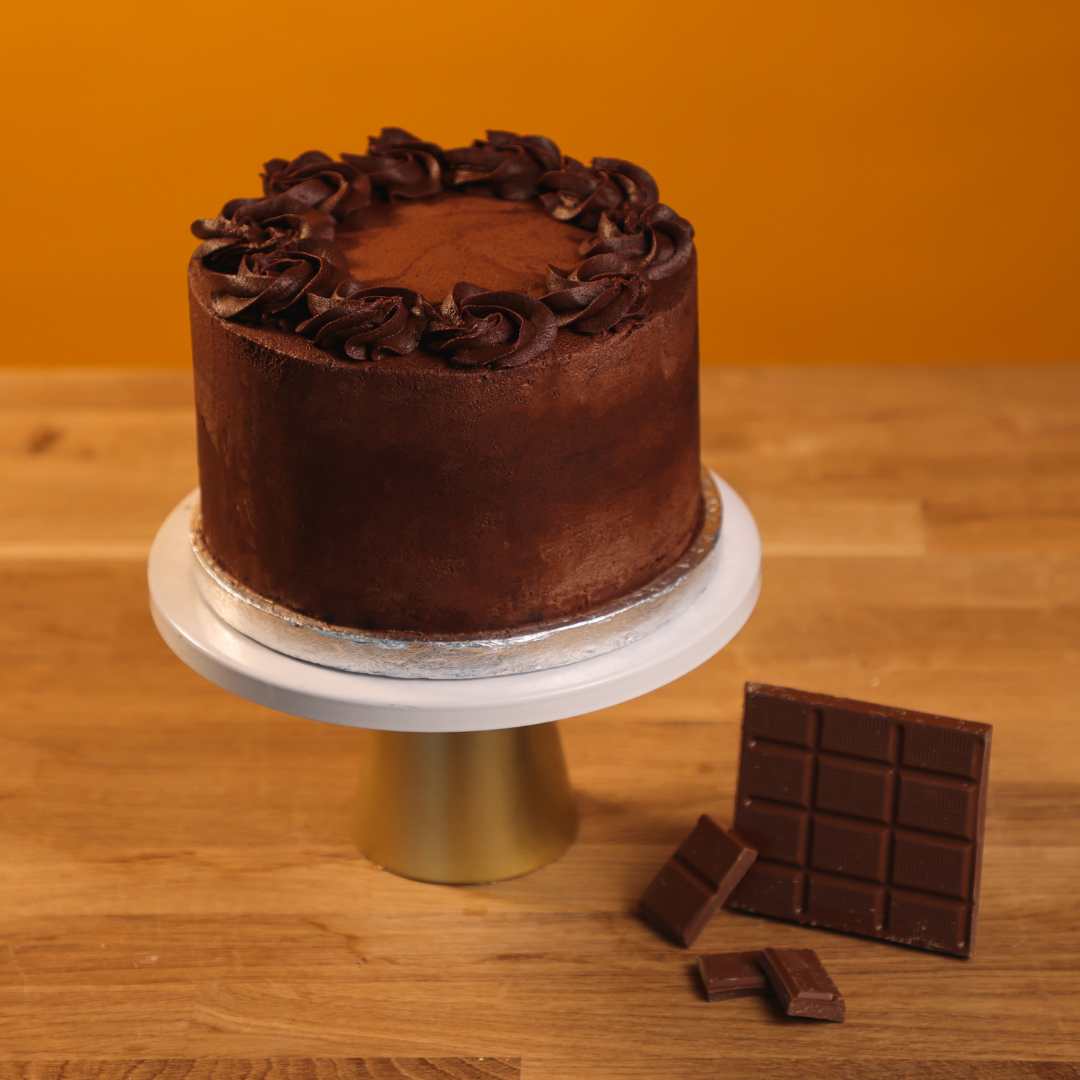 A Last-Minute Birthday Cake by No Guilt Bakes sits on a table next to chocolate bars.