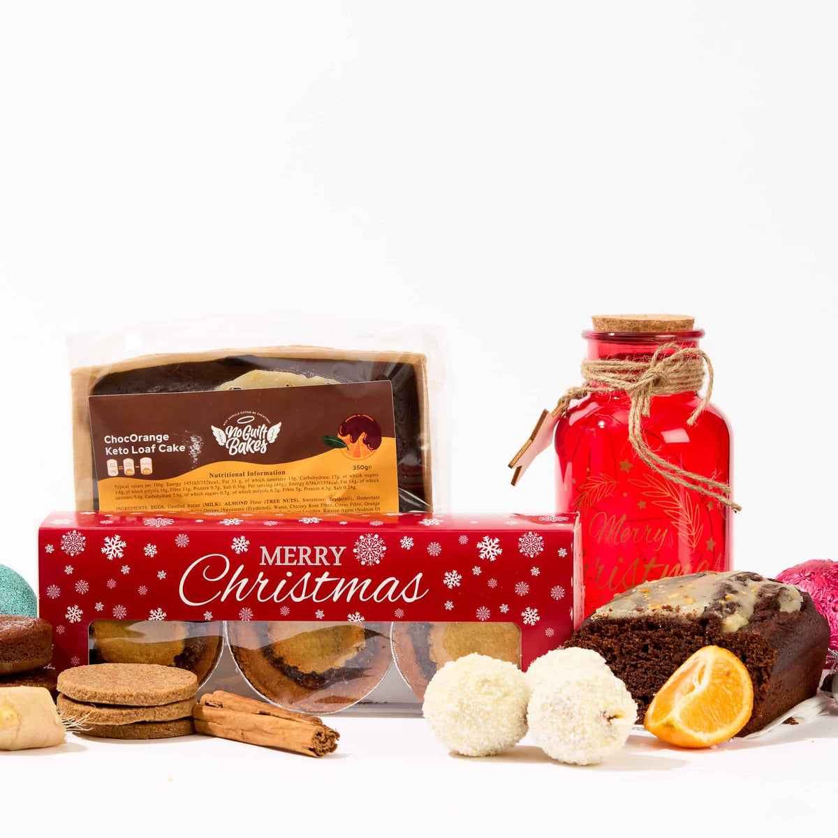 The No Guilt Bakes Christmas Keto Treat Box includes a variety of festive treats such as cookies and a jar.